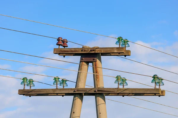 Oude betonnen hoogspanningsleiding met isolatoren en draden tegen blauwe lucht — Stockfoto