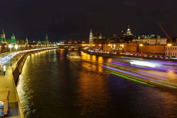 Trilha brilhante de barco de prazer navegando ao longo do rio Moskva contra aterro à noite — Fotografia de Stock