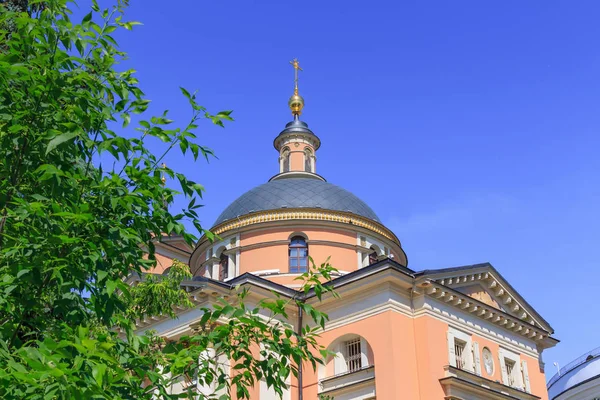 Москва, Россия - 3 июня 2018 года: Храм великомученицы Барбары на улице Варварка в Москве на синем фоне неба на зеленом дереве в солнечный день — стоковое фото