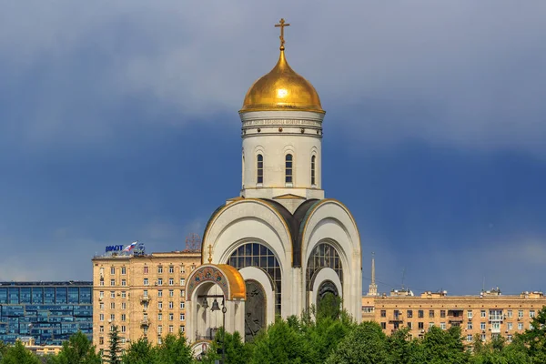 Москва, Россия - 09 июня 2018 года: Храм Великомученика Георгия Победоносца с золотым куполом на Поклонной горе в Москве на фоне домов в солнечный день — стоковое фото