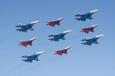 Moscow, Russia - May 07, 2019: Fighters Su-30SM and MiG-29 of Russian Knights and Swifts aerobatic teams in famous Kubinsky Diamond over Red Square. Aviation part of Victory parade 2019 in Moscow clipart