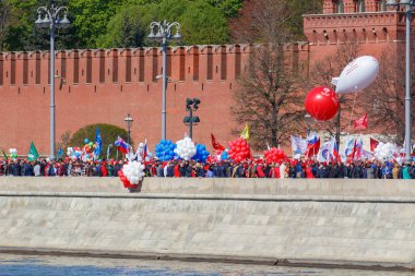 Moskova, Rusya - 01 Mayıs 2019: Kremlin duvarına karşı Kremlevskaya seti üzerinde bayraklar ve renkli balonlar ile göstericiler. Moskova'da 1 Mayıs kutlaması