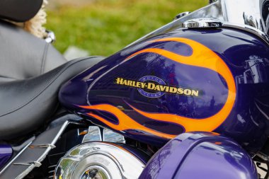 Moskova, Rusya - 04 Mayıs 2019: Harley Davidson motosiklet amblemi ve turuncu alevler yakın çekim ile parlak mavi yakıt tankı. Moto festivali Mosmotofest 2019