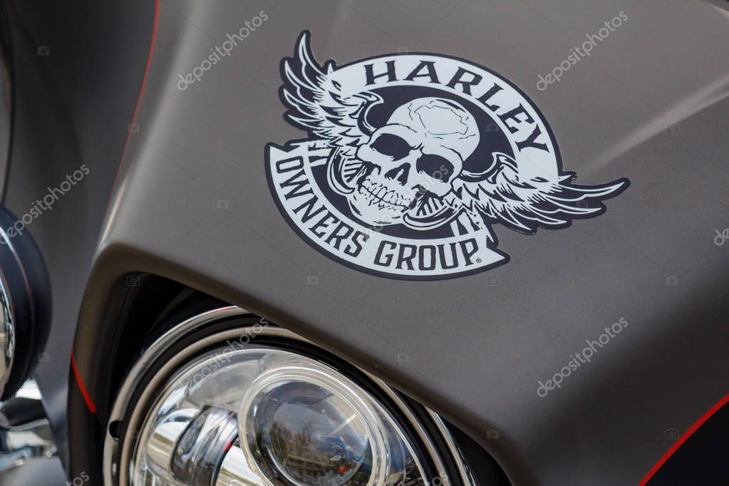 Moscow, Russia - May 04, 2019: Emblem of Harley Owners Group with skull and wings on matte black windproof shield of Harley Davidson motorcycle. Moto festival MosMotoFest 2019