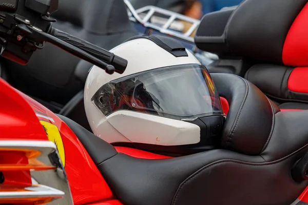 Moscou, Russie - 04 mai 2019 : Casque de moto blanc avec visière fermée repose sur un siège en cuir de moto gros plan. Moto festival MosMotoFest 2019 — Photo