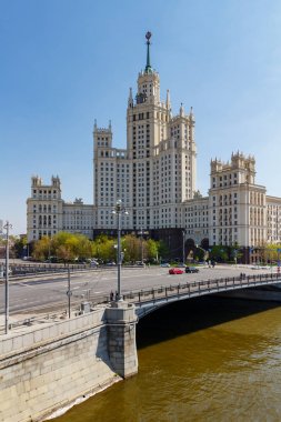 Moskova, Rusya - 01 Mayıs 2019: Yauza nehri üzerindeki Malyi Ustyinskiy Köprüsü, Moskova'daki Kotelnicheskaya Embankment'taki Stalin gökdeleninin arka planında güneşli bahar sabahında mavi gökyüzüne karşı