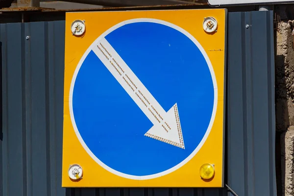 Тимчасовий дорожній знак зі стрілкою, що вказує напрямок оточення крупним планом — стокове фото