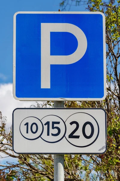 Znak drogowy płatny parking przed zielonymi drzewami i błękitnym niebem w słoneczny dzień zbliżenie — Zdjęcie stockowe
