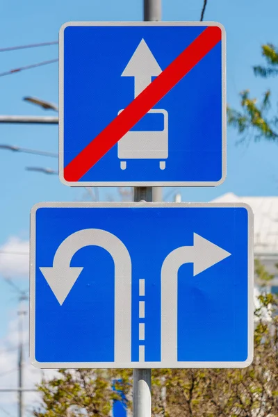 Verkeersborden richting verkeer op de steegjes close-up tegen groene bomen en blauwe hemel in zonnige dag — Stockfoto