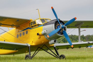 Sovyet uçak çift kanatlı Antonov An-2 sarı gövde ile bulutlu bir günde havaalanı closeup yeşil bir çim üzerine park