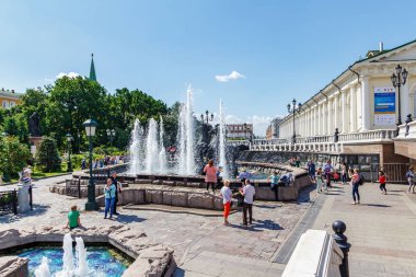 Moskova, Rusya - 02 Haziran 2019: Güneşli yaz sabahında Moskova'daki Manezhnaya Meydanı'nda çeşme Gayzeri'nin yakınında turistler