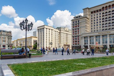 Moskova, Rusya - 02 Haziran 2019: Turistler yeşil çimenlerin arka planında güneşli yaz sabahında Moskova'daki Manezhnaya Meydanı'nda yürüyorlar