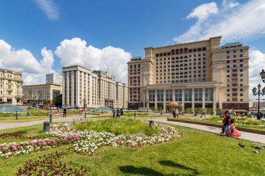 Moskova, Rusya - 02 Haziran 2019: Güneşli yaz sabahında mavi gökyüzü arka plan üzerinde çeşmeler ve yeşil çimler ile Moskova'da Manezhnaya Meydanı görünümü