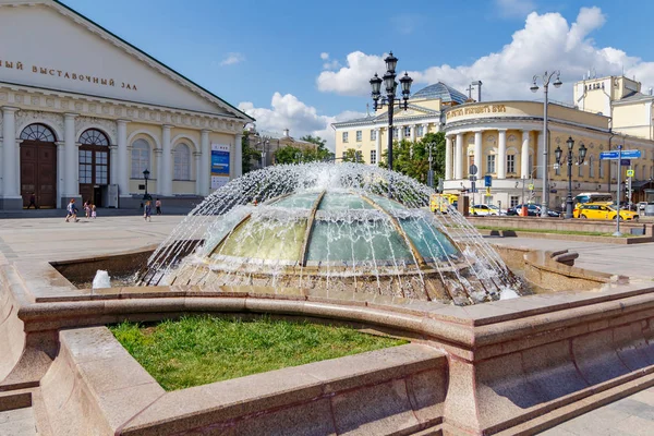 Moscow, Russia - June 02, 2019: Working dome fountain on Manezhnaya Square in Moscow on a background of Central exhibition hall Manege and House temple of Martyr Tatiana at sunny summer morning — Stock Photo, Image