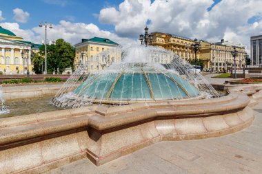 Moscow, Russia - June 02, 2019: Dome fountain on Manezhnaya Square in Moscow at sunny summer morning against blue sky with white clouds clipart