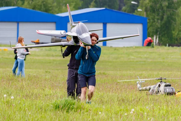 Balashikha, Moscow region, Russia - May 25, 2019: Team members of Aviation Sports Club RusJet carry a big scale RC model of jet aircraft at aviation festival Sky Theory and Practice 2019