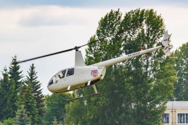 Balashikha, Moskova Bölgesi, Rusya-25 Mayıs, 2019: helikopter Robinson R44 Raven ra-06359 Havacılık Festivali gökyüzü teorisi ve uygulama 2019 at Havaalanı Chyornoe üzerinde yeşil ağaçlara karşı uçar