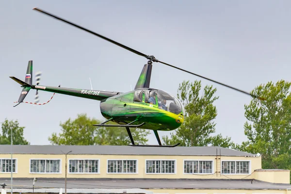 Balashikha, Moscow Region, Rusland-25 mei 2019: Helicopter Robinson R44 Raven Ra-07368 vliegt tegen groene bomen over vliegveld Chyornoe bij de luchtvaart Festival hemel theorie en praktijk 2019 — Stockfoto