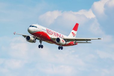 Moscow, Russia - June 21, 2019: Aircraft Airbus A320-232 VP-BWY of Red Wings airline landing at Domodedovo international airport in Moscow on a cloudy blue sky background at sunny day clipart