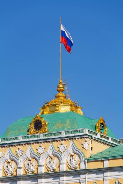 Moskova, Rusya - 01 Mayıs 2019: Moskova Kremlin Grand Kremlin Sarayı'nın altın kubbesi, Rusya Federasyonu'nun mavi gökyüzü arka planında yakın çekim bayrağını sallıyor