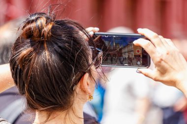 Moskova, Rusya - 02 Haziran 2019: Kadın güneşli yaz günü closeup Moskova'da Kızıl Meydan'da modern akıllı telefon bir fotoğraf çeker