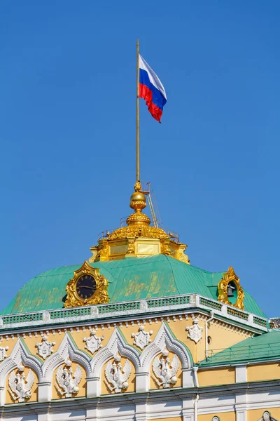 Moscú, Rusia - 01 de mayo de 2019: cúpula dorada del Gran Kremlin Palacio del Kremlin de Moscú con bandera ondeante de la Federación Rusa de cerca sobre un fondo azul del cielo Imágenes De Stock Sin Royalties Gratis