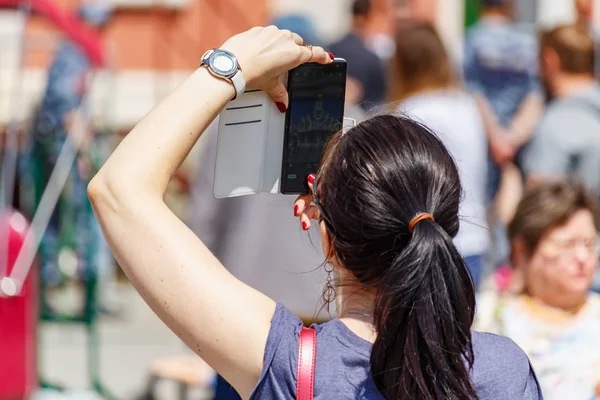 Moscú, Rusia - 02 de junio de 2019: Mujer toma una foto en el teléfono inteligente moderno en la Plaza Roja de Moscú en el primer día de verano soleado Imagen De Stock