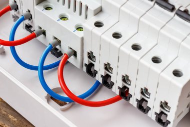 Otomatik devre kesicilerin kırmızı ve mavi kablolarla birbirine bağlı bağlantı noktaları