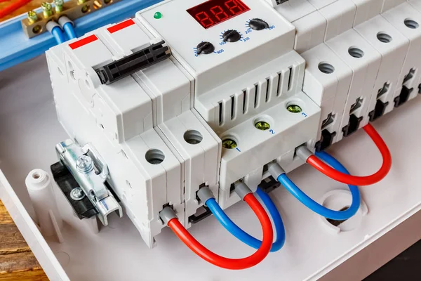 Alambres rojos y azules conectados a los puertos del limitador de voltaje y primer plano del interruptor automático de doble entrada —  Fotos de Stock