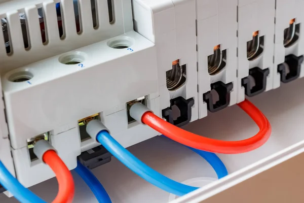 Puertos de interruptores automáticos instalados conectados por cables rojos y azules de primer plano —  Fotos de Stock