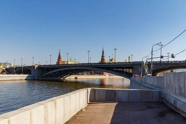 Moskwa, Rosja-maj 01, 2019: Pier na nabrzeża Bersenevskaya rzeki Moskva z Bolshoy Kamenny Bridge i wieże Moskiewskiego Kremla na niebieskim tle nieba w słoneczny poranek — Zdjęcie stockowe