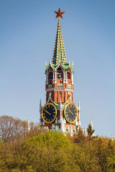 Moscou, Rússia - 01 de maio de 2019: Torre Spasskaya de Moscou Kremlin com estrela de rubi em um fundo de céu azul e árvores verdes em um fundo de céu azul — Fotografia de Stock