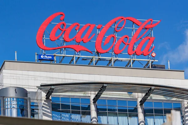 Moskova, Rusya - 04 Mayıs 2019: Coca Cola, Moskova'nın merkezindeki modern binanın çatısında, güneşli sabahlarda beyaz bulutlarla mavi gökyüzüne karşı yakın çekim yaptı. Coca Cola işareti