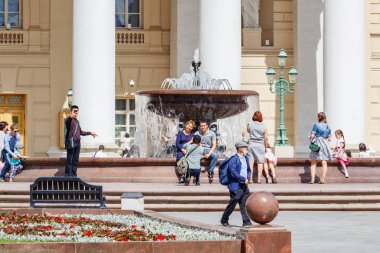 Moskova, Rusya - 02 Haziran 2019: Turistler güneşli bir günde Moskova'daki Teatralnaya Meydanı'ndaki çeşmenin yanındaki Bolşoy Tiyatrosu'nun arka planında fotoğraf çekiyor
