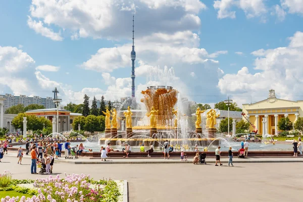 Moscú, Rusia - 22 de julio de 2019: Fuente de la amistad de los pueblos en el parque VDNH en Moscú sobre un fondo de la torre de televisión Ostankinskaya contra el cielo azul con nubes blancas en el soleado día de verano — Foto de Stock