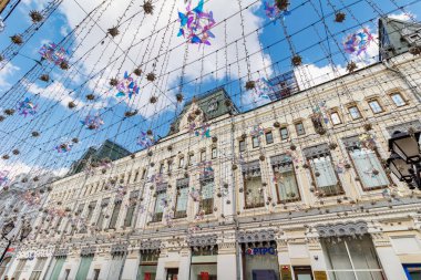 Moskova, Rusya - 28 Temmuz 2019: Güneşli yaz sabahında dekoratif çelenklere karşı Moskova'nın Nikolskaya caddesindeki vintage binanın cephesi