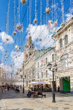 Moskova, Rusya - 28 Temmuz 2019: Güneşli yaz sabahında beyaz bulutlarla mavi gökyüzüne karşı Moskova'da Nikolskaya caddesinin üzerinde dekoratif çelenkler