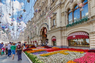Moskova, Rusya - 28 Temmuz 2019: Güneşli yaz gününde Moskova'da çiçeklerle süslenmiş Nikolskaya caddesi. Gum Devlet Mağaza geleneksel yıllık Çiçek Festivali