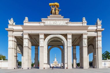 Moskova, Rusya - 22 Temmuz 2019: Moskova'daki Vdnh parkının ana girişinin üzerindeki yay cephesi, güneşli yaz sabahında mavi gökyüzüne karşı