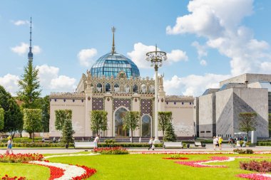 Moskova, Rusya - 22 Temmuz 2019: Güneşli yaz sabahında çiçeklerle yeşil çime karşı Moskova'daki Vdnh'de Kazakistan Cumhuriyeti pavyonu