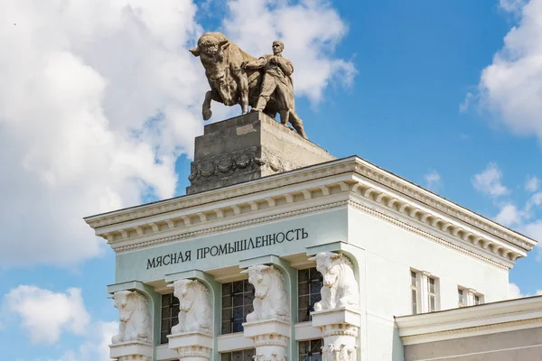 Moscú, Rusia - 22 de julio de 2019: Escultura Luchador con un toro en el techo del pabellón de la industria cárnica en VDNH en Moscú contra el cielo azul en la soleada mañana de verano. Arquitectura del parque VDNH — Foto de Stock