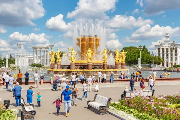 Moscú, Rusia - 22 de julio de 2019: Turistas caminando por la plaza cerca de la fuente de la Amistad de los Pueblos en el parque VDNH en Moscú en el soleado día de verano. El parque VDNH es un popular punto de referencia turístico — Foto de Stock