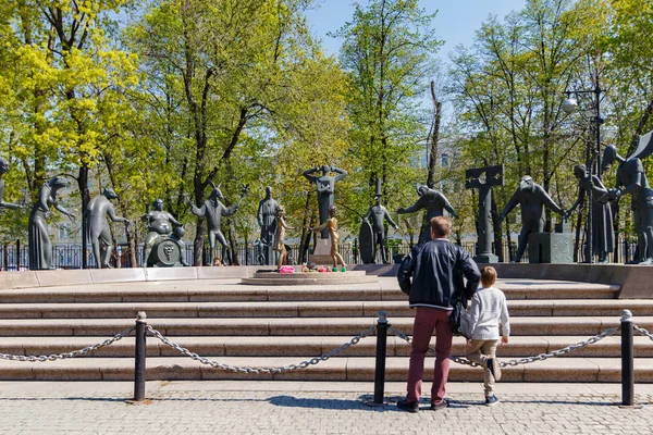 Moskou, Rusland-mei 01, 2019: man en kind in de buurt van beeldhouwkunst kinderen-slachtoffers van volwassen diensten op Bolotnaya plein in Moskou op zonnige lente ochtend — Stockfoto