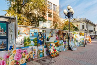 Moskova, Rusya - 13 Eylül 2019: Moskova'da Arbat caddesinde güneşli sonbahar sabahında eski binaların arka planı üzerinde sanat galerisi