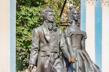 Moskova, Rusya - 13 Eylül 2019: Moskova'da Arbat caddesinde Alexander Puşkin ve Natalia Goncharova Anıtı güneşli sonbahar sabahında yeşil ağaçlara yakın çekim