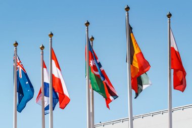 Güneşli sabahmavi gökyüzüne karşı farklı ülkelerin bayrakları