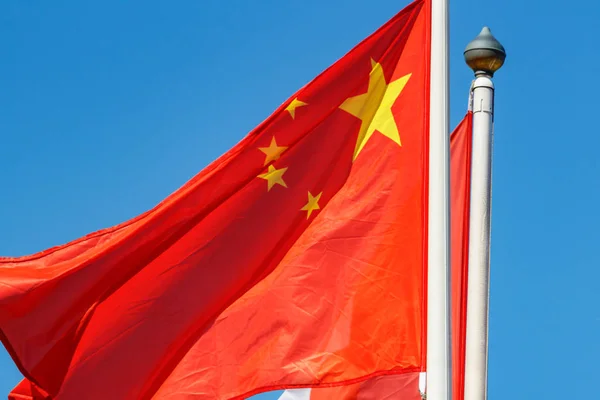 Флаг Китая крупным планом машет на ветру на голубом фоне неба — стоковое фото