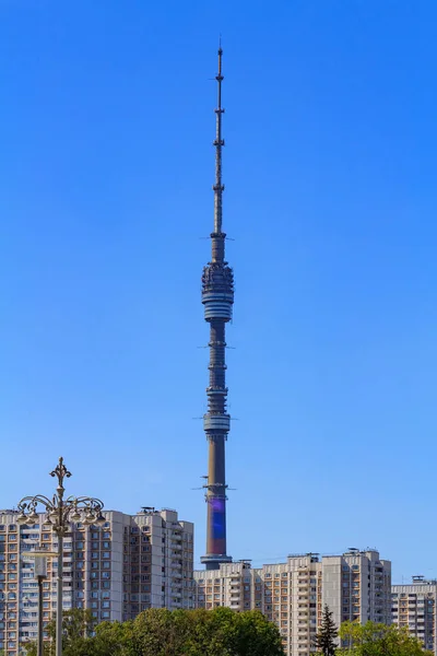 Beskåda av Ostankino Television står hög på en bakgrund av höga byggnader i solig sommarmorgon — Stockfoto