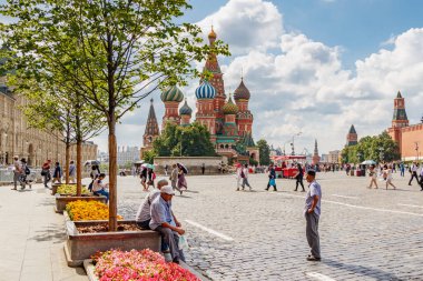 Moskova, Rusya - 28 Temmuz 2019: Saint Basil Katedrali'ne karşı güneşli yaz sabahında Moskova'da Kızıl Meydan'da yürüyen farklı ülkelerden gelen turistler