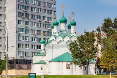 Moskova, Rusya - 13 Eylül 2019: Povarskaya caddesindeki Aziz Simeon Kilisesi, güneşli sonbahar gününde Yeni Arbat caddesindeki Sovyet gökdelenine karşı